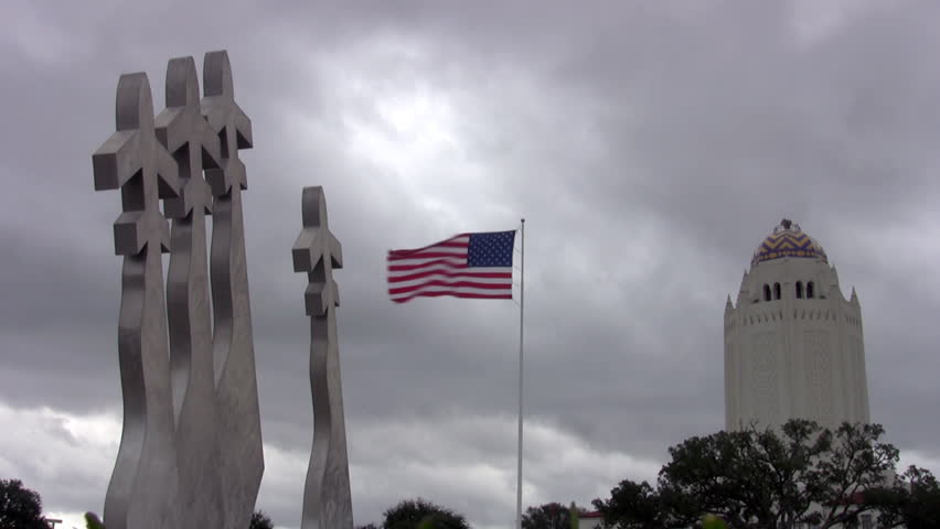 Video fast time lapse of USA flag at Randolph AFB, San Antonio, Texas. Missing man formation of aircraft monument. Cloudy and windy day with flag waving and clouds moving.  