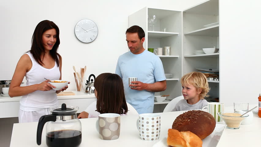 Family taking breakfast together in the kitchen at home