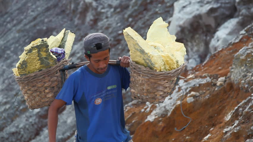 EAST JAVA, INDONESIA - June 18 : Worker lifts up the sulfur from the bottom of the crater June 18 2010 in Volcano, Java, Indonesia.