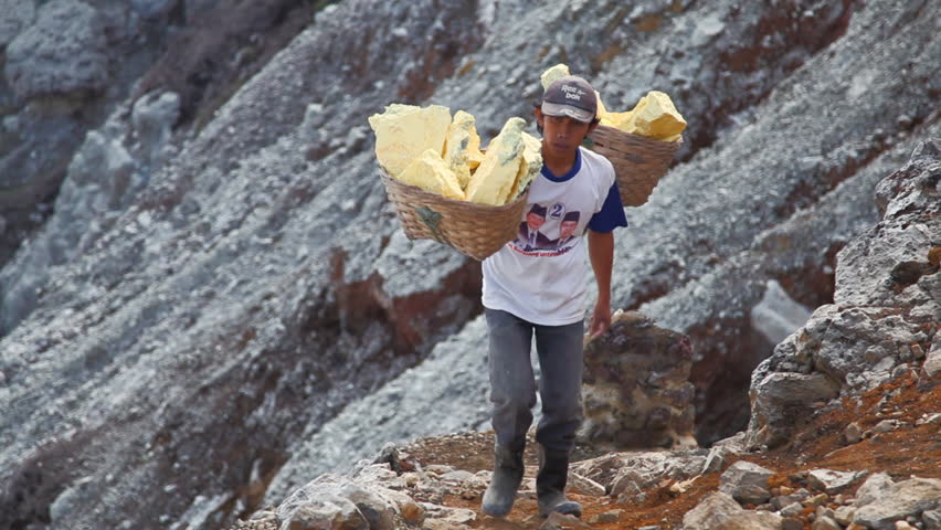 EAST JAVA, INDONESIA - June 18 : Worker lifts up the sulfur from the bottom of the crater June 18 2010 in Volcano, Java, Indonesia.