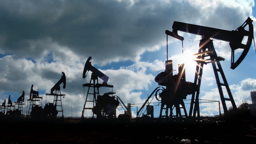 working oil pumps silhouette against timelapse clouds