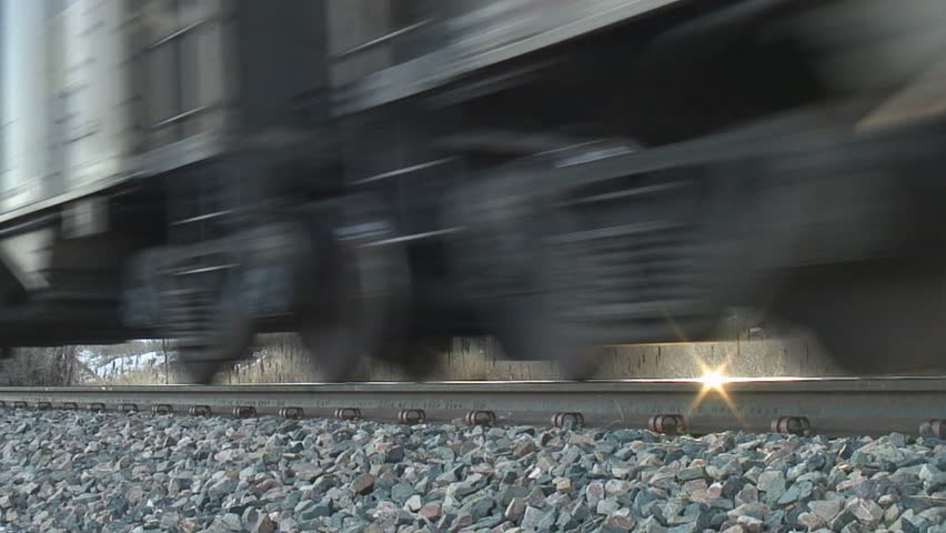 Rail-level tight shot of coal train wheels passing by; HD, audio