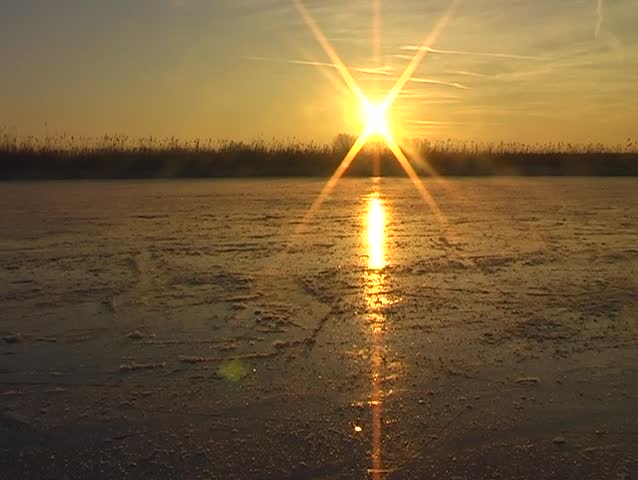 Ice skating at sunset in the countryside of the Netherlands on a cold winterday