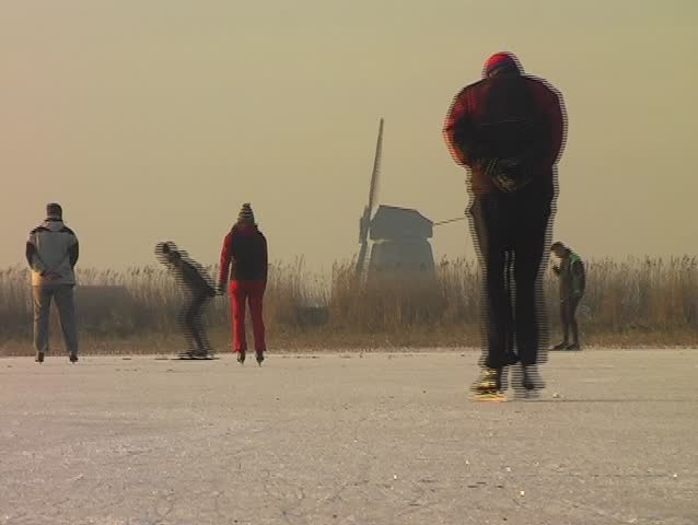 Ice skating on the fields in the countryside of the Netherlands on a cold winterday