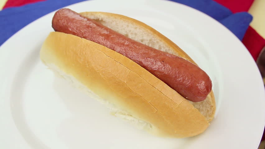 Squeezing american mustard on a hot dog 