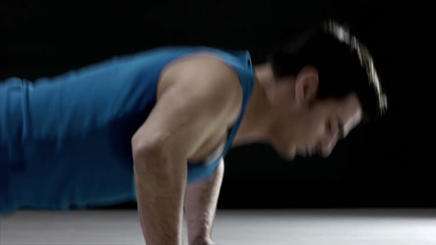Young caucasian male in sportswear doing push ups on black background. Sequence