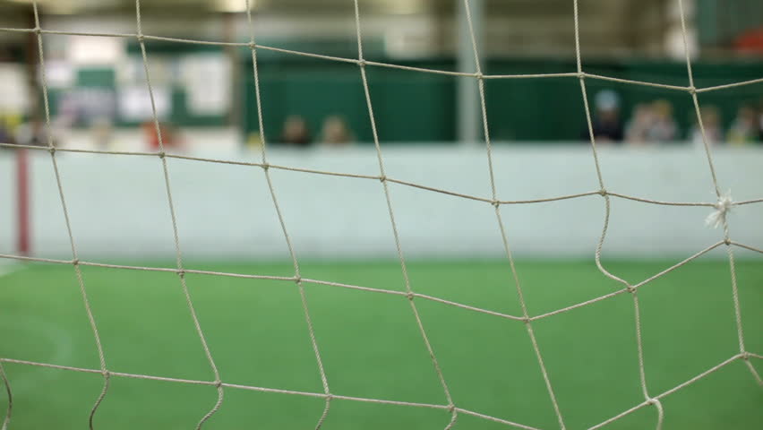 Children playing soccer focused on net