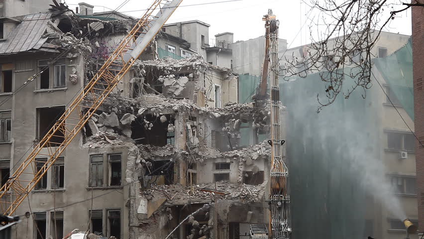 Building demolition. Dust, debris and water. General view, establishing shot. 