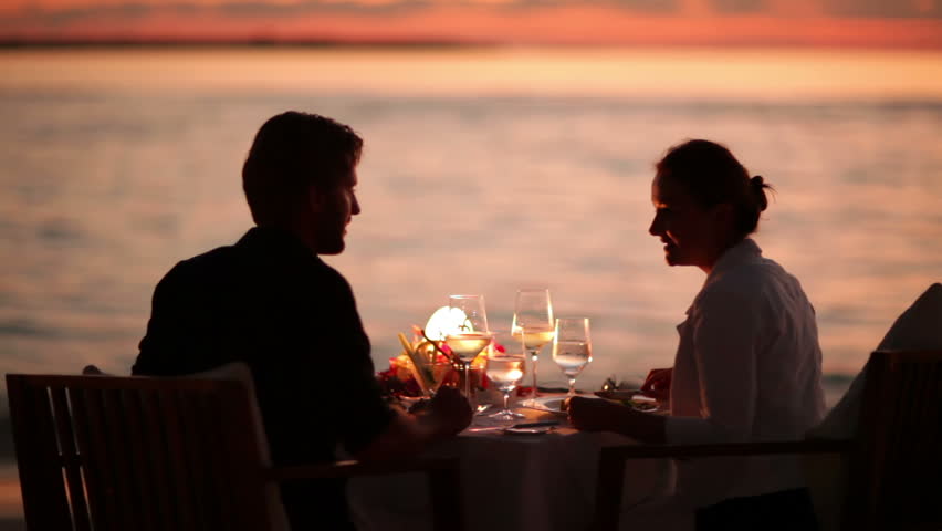 young couple dining and feeding each other on a tropical beach at sunset with audio 