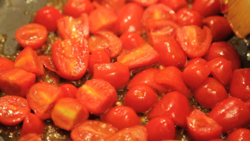Mediterranean food: cooking fresh pachino tomatoes to season pasta, close-up