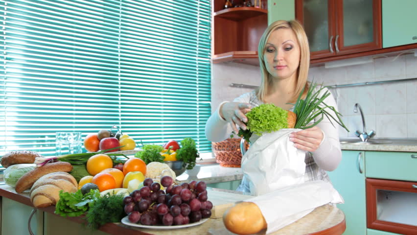 Pregnant woman Unloading Groceries from the Bag in the kitchen
