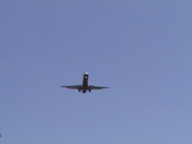 Modern passenger jetliner landing against blue sky