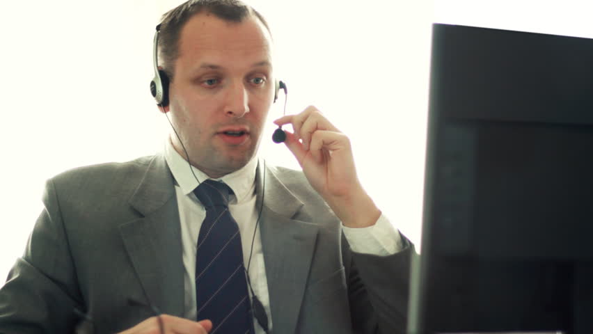 Male helpdesk consultant talking on headset