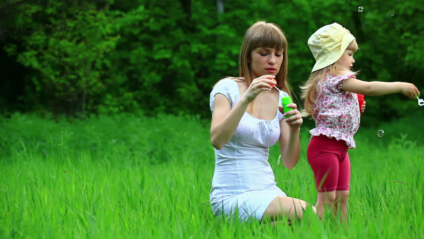 Mother and daughter blowing air bubbles. Tripod. 