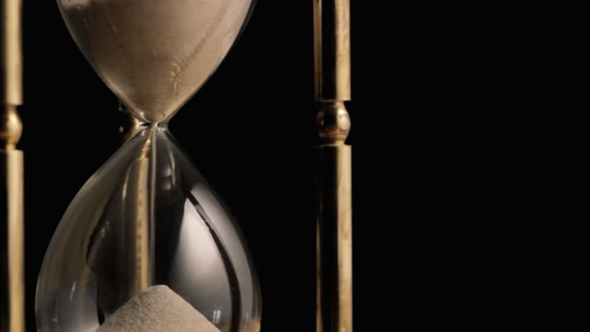 Slowly rotating hourglass with sand running through