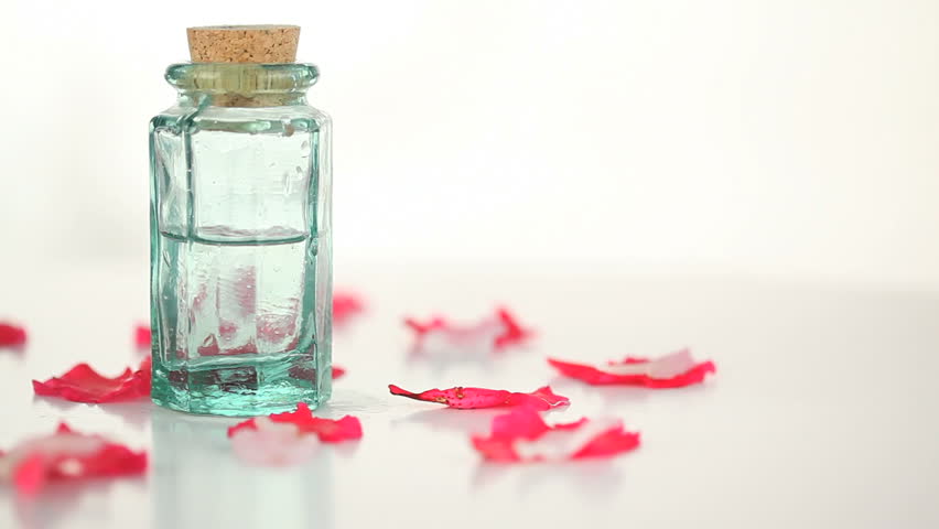 Massage lotion turning with flowers petals on a white background