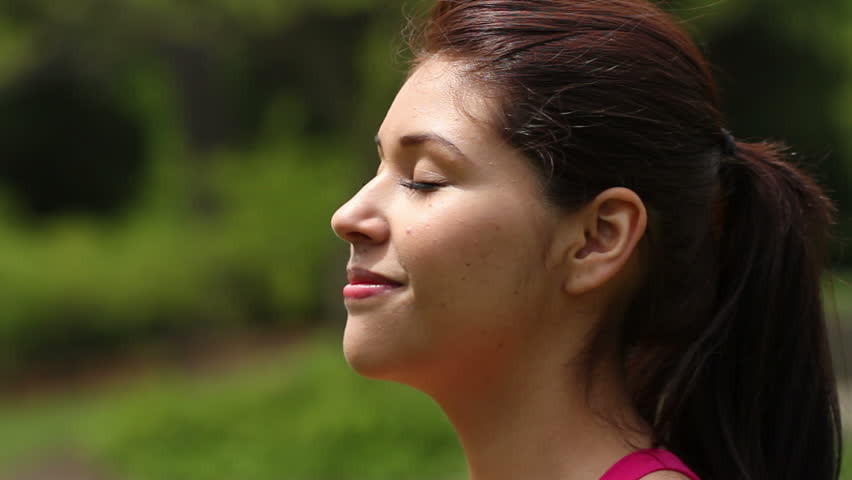 Pretty young woman basking in the sun, smiling