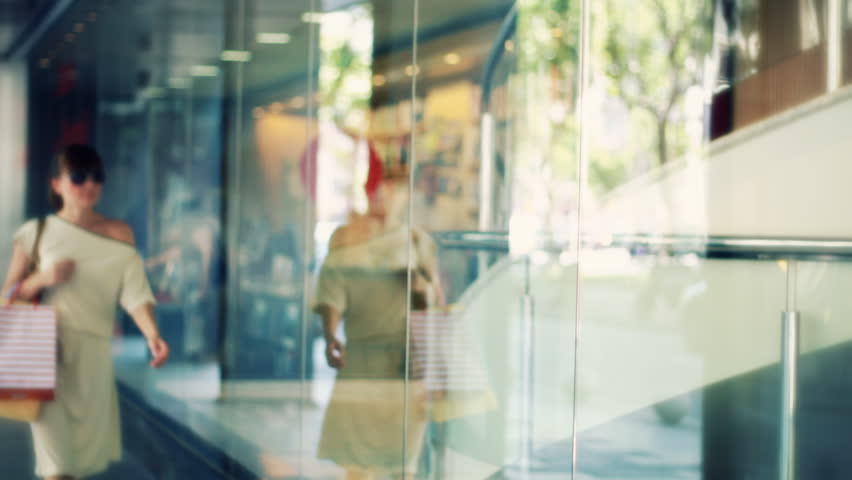 Young attractive shopping woman stopping to marvel shop window