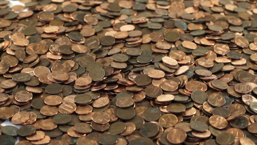 Thousands of pennies poured onto a table all at once.