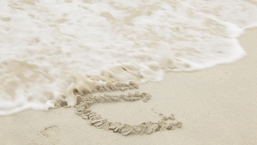 Euro sign drawn in the sand of an ocean beach is threatened by a first wave, and then completely obliterated out by a second one. Conceptual clip for a weak or eroding Euro.