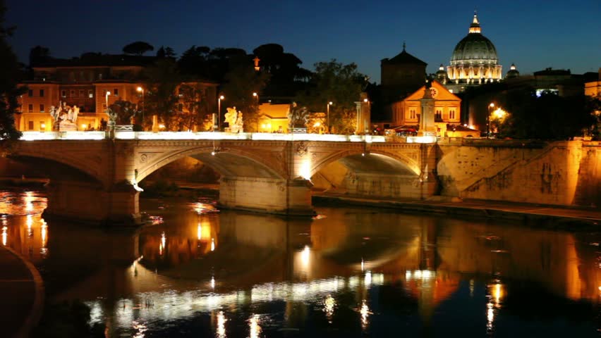 Cityscape bridge over the river, the dome of Saint Peters Cathedral is seen behind the buildings, little traffic on bridge and quay