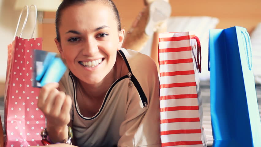 Portrait of smiling woman with shopping bags and credit card