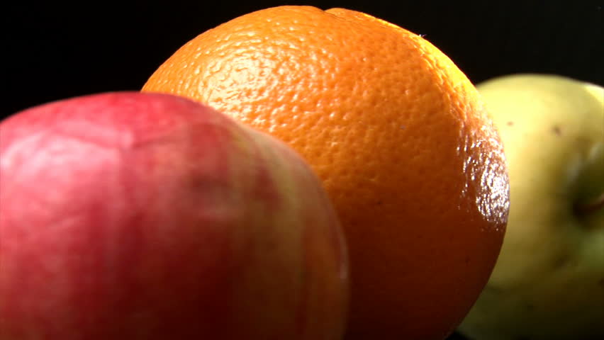 Fruits (orange, lemon and apple) slow rotate. Solar system concept.
