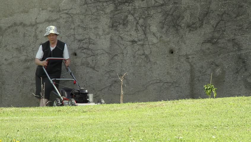 Sprightly old lady mowing the lawn