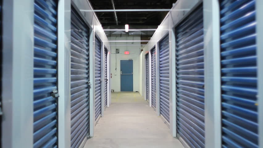 Industrial hallway.  Moving backwards down an industrial hallway in a storage warehouse. Dolly shot from a skateboard. 