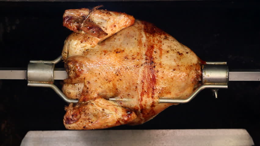 A chicken barbecued on a rotating spit. Seamless loop.