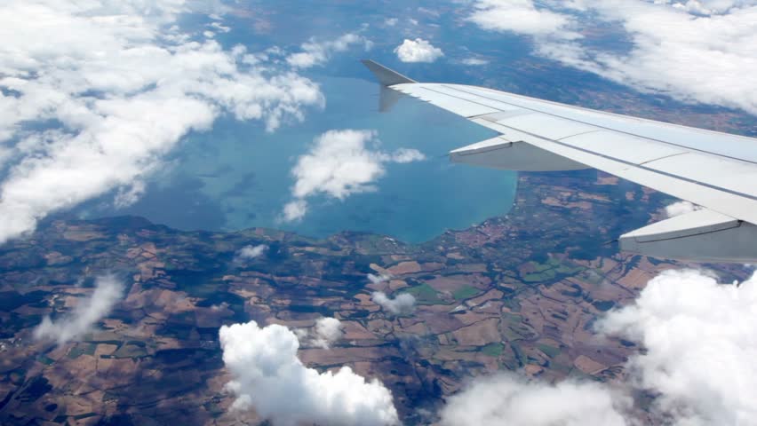 Aircraft turn at flight over sea shore, view from porthole