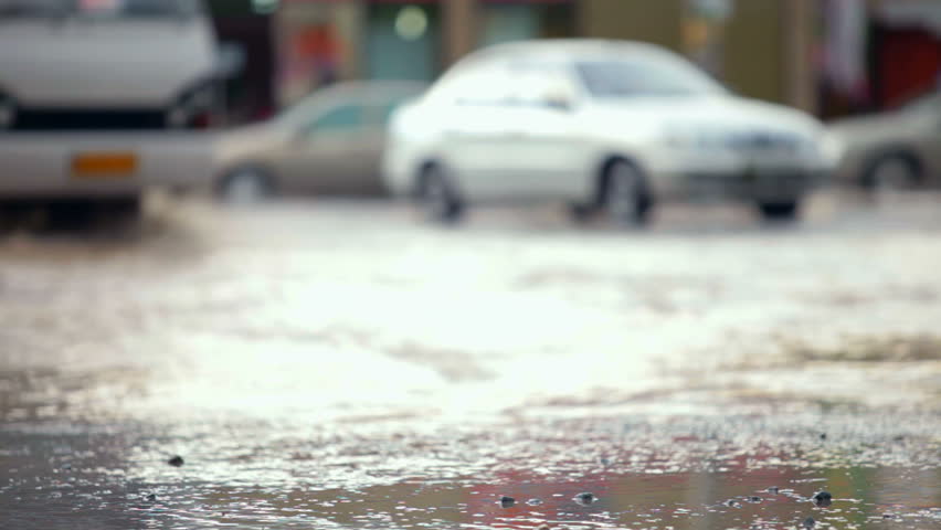 car splashes on flooded street
