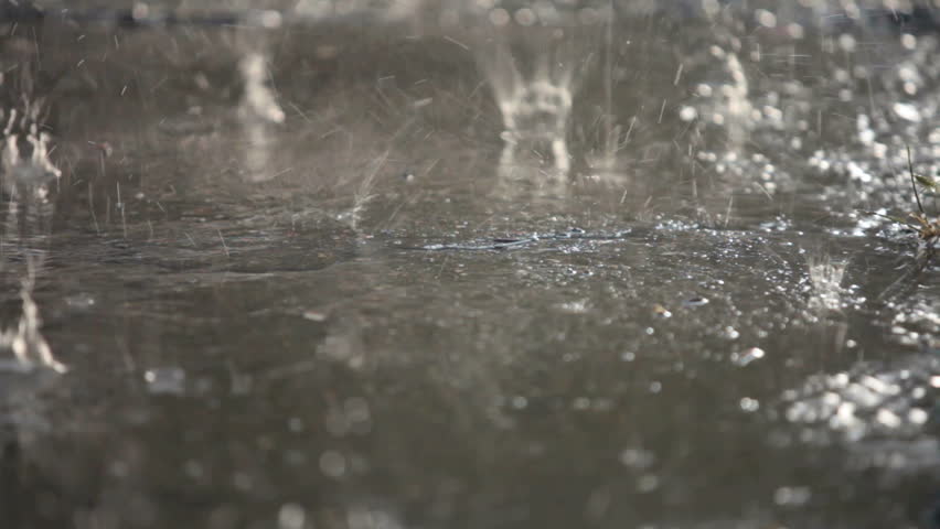 Raindrops are broken with splashes  falling on the asphalt