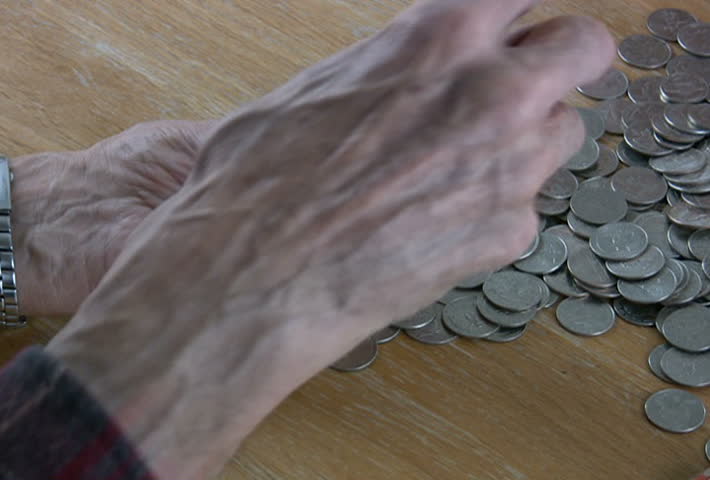 A senior man folding the ends on a roll of quarters. Converted to NTSC from HDV 1080i60.
