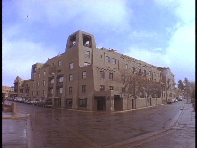 An adobe style building stands on a street corner in Santa Fe, New Mexico.