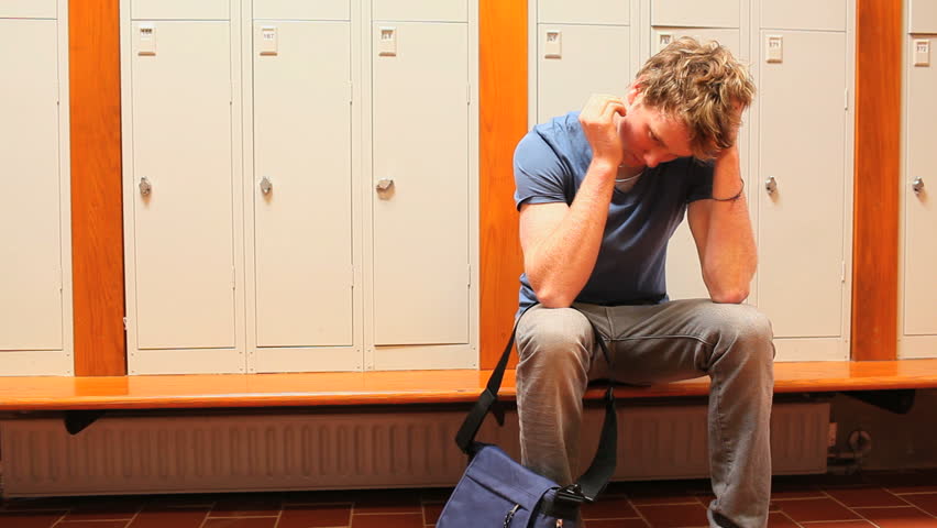 Upset student holding his head while sitting on a bench