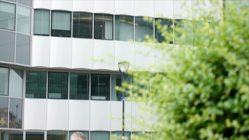 Mid adult businessman with cellphone, typing and browsing the internet as white collar worker