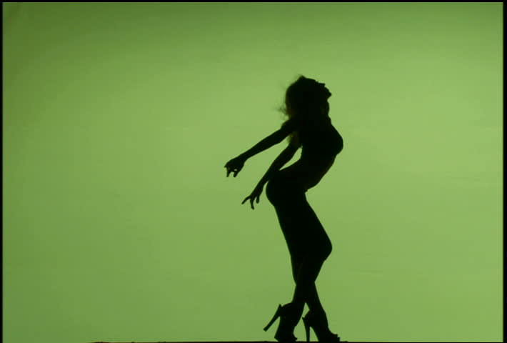 A silhouetted woman dancing against green background