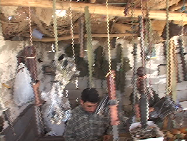 IRAQ - CIRCA 2003: Weapons dealers work in their arsenal circa 2003 in Northern Iraq.