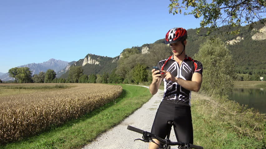 young man riding bicycle and text messaging on mobile phone. Crane shot