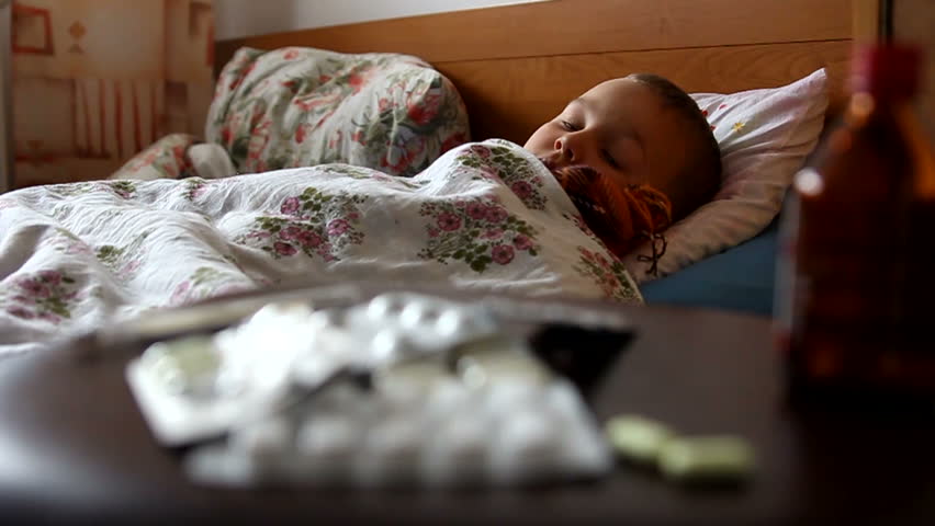 Sick child is lying in a bed