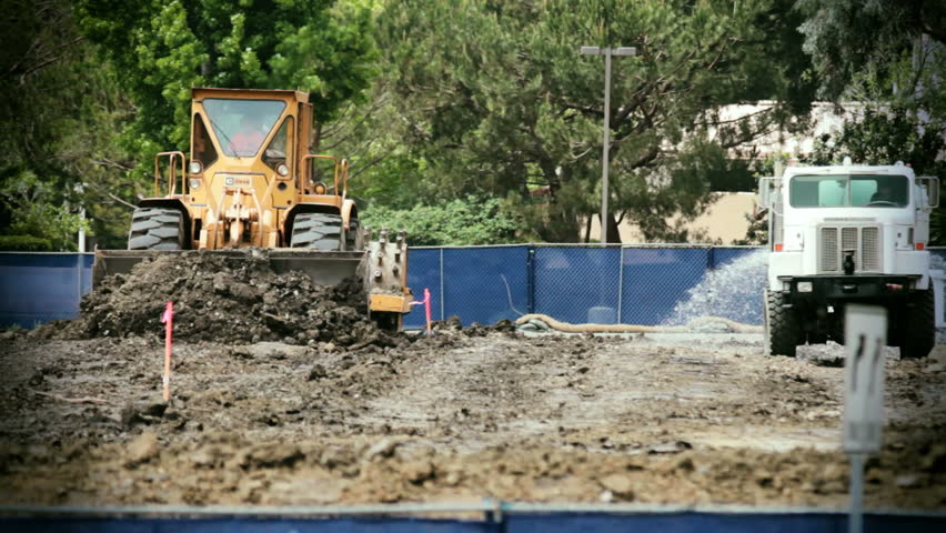 Bulldozer and water truck moving towards cam