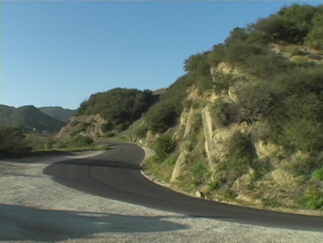 A white vehicle on a winding country road.
