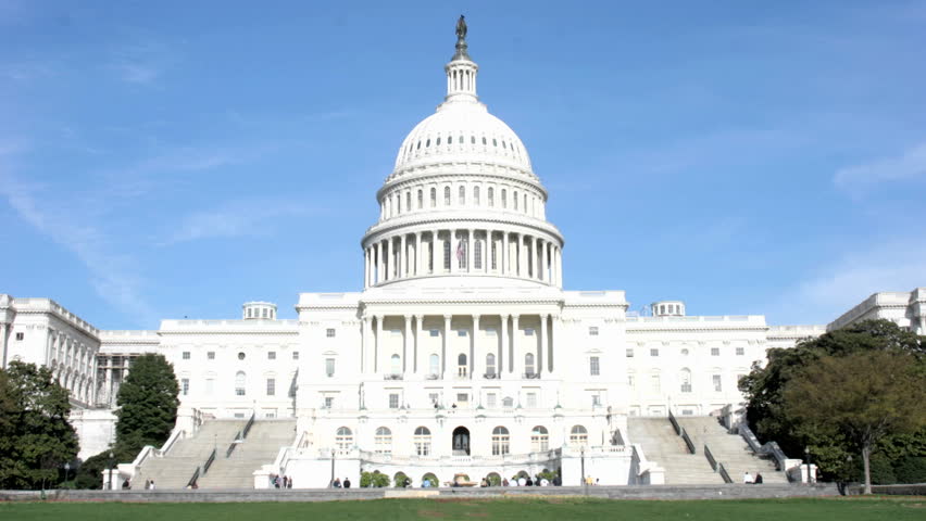 Visitors and legislators walk into and out of the United States Capitol Building.