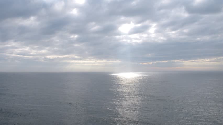 White clouds pass above ship at open sea, time lapse