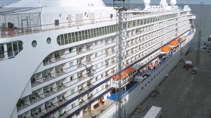 Enormous cruise liner stationed at bay, top-down view, time lapse