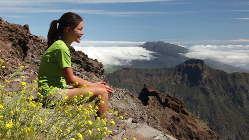 Hiking. Hiker looking at spectacular view over beautiful landscape on the summit of the   Canary Island of La Palma. Young beautiful woman hiker.