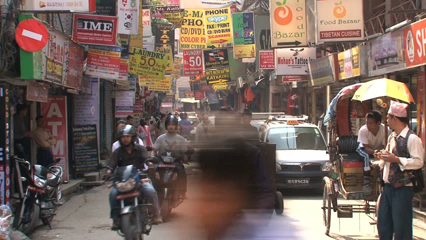 KATHMANDU - CIRCA 2010: People, cars and bikes circulate through the city circa 2010 in Kathmandu.