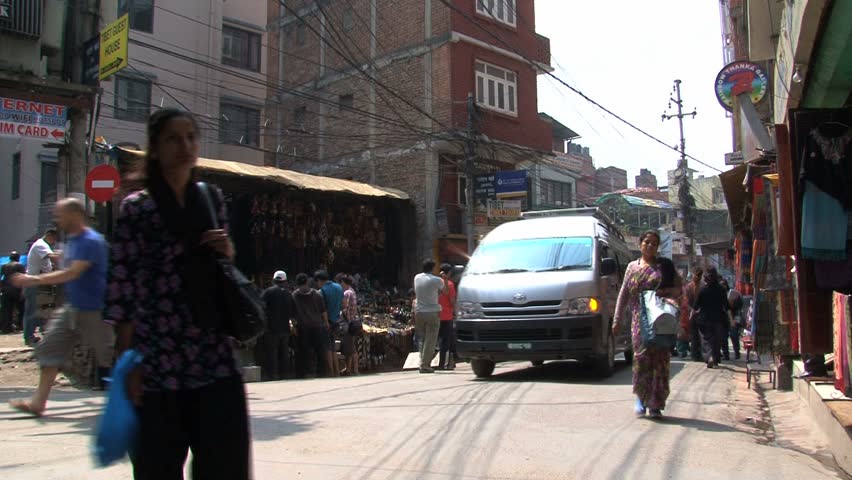KATHMANDU - CIRCA 2010: People, cars and bikes circulate through the city circa 2010 in Kathmandu.