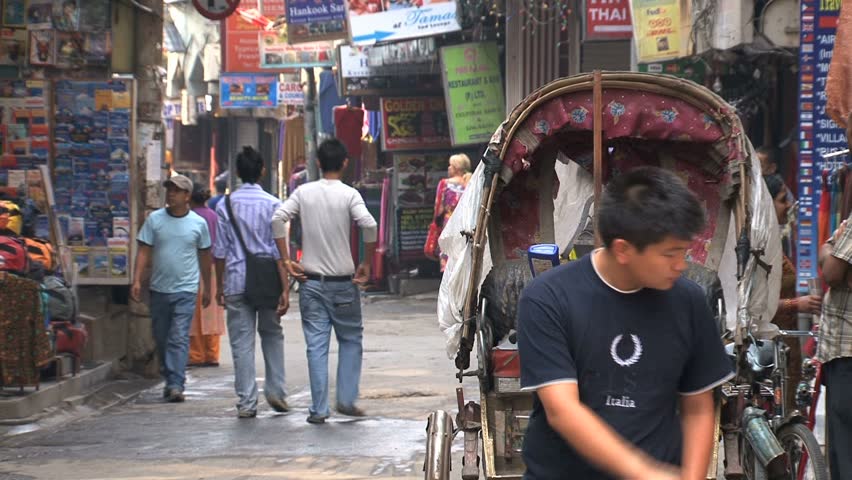 KATHMANDU - CIRCA 2010: People, cars and bikes circulate through the city circa 2010 in Kathmandu.